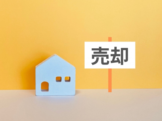 家の模型と「売却」と書かれた表示