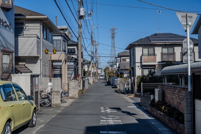 住宅街の細い道路と電柱が立ち並ぶ風景