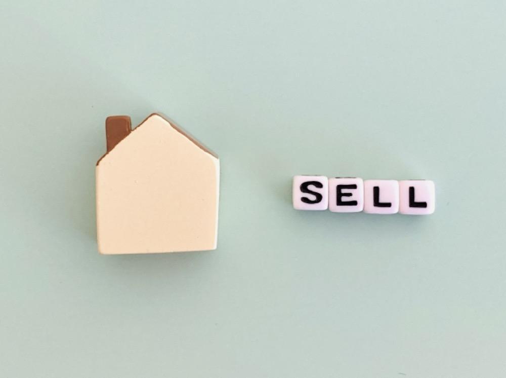 家のアイコンと「SELL」の文字ブロックが並ぶシンプルな構成