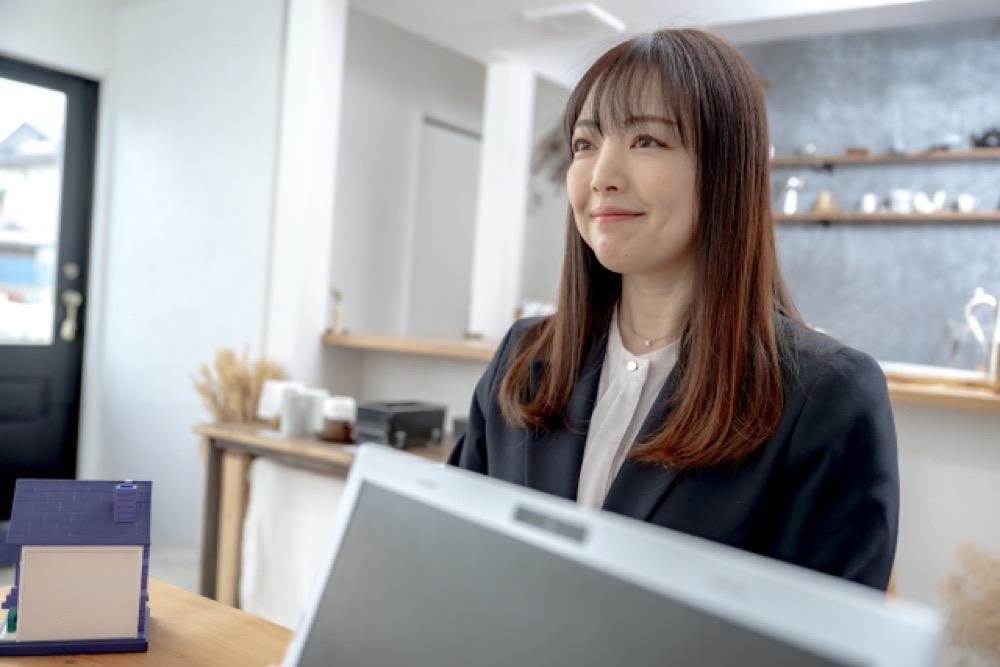 不動産会社の女性スタッフが接客中に笑顔を見せている様子